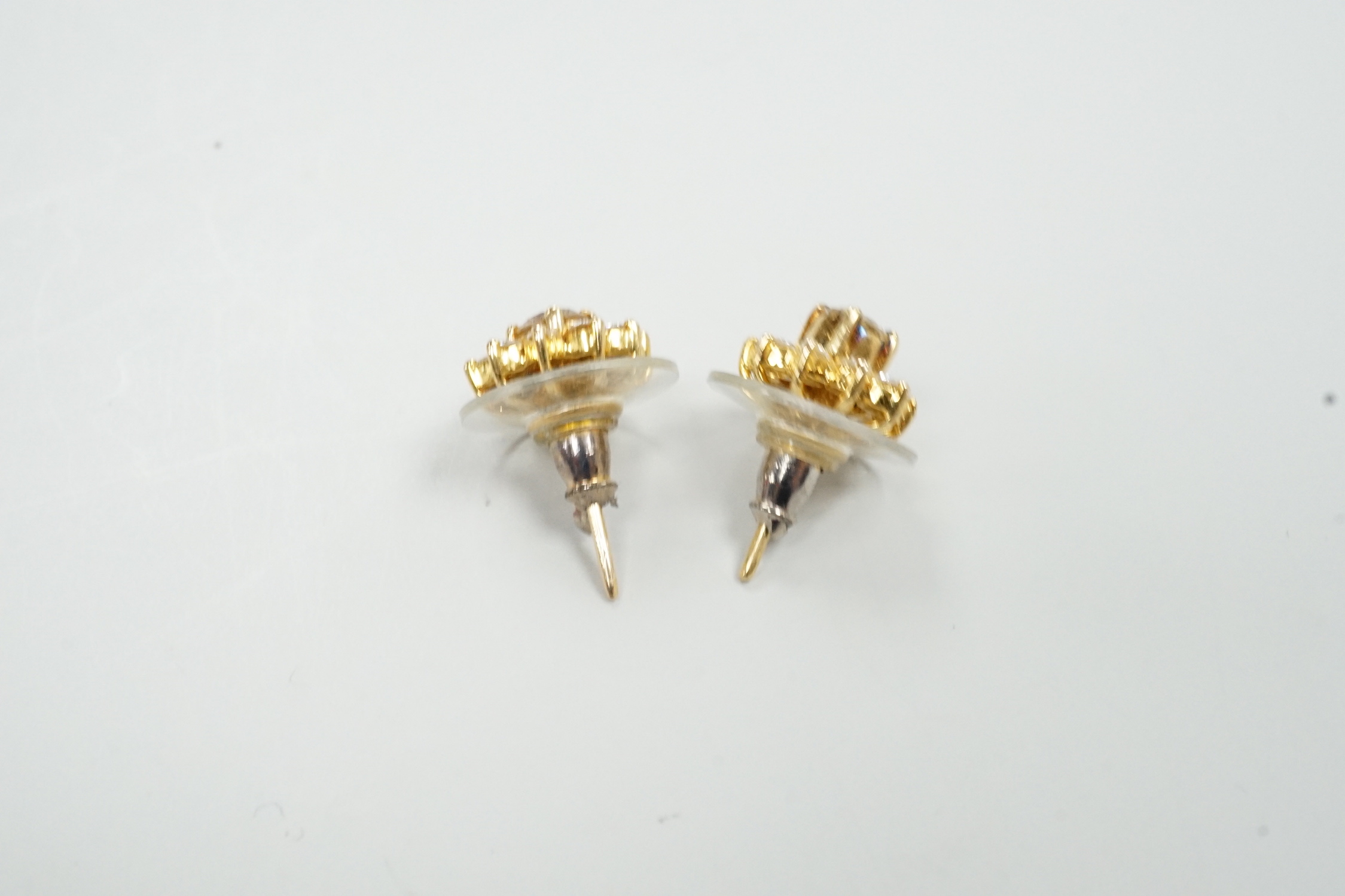 A modern pair of yellow metal and diamond cluster set flower head ear studs, with detachable collars